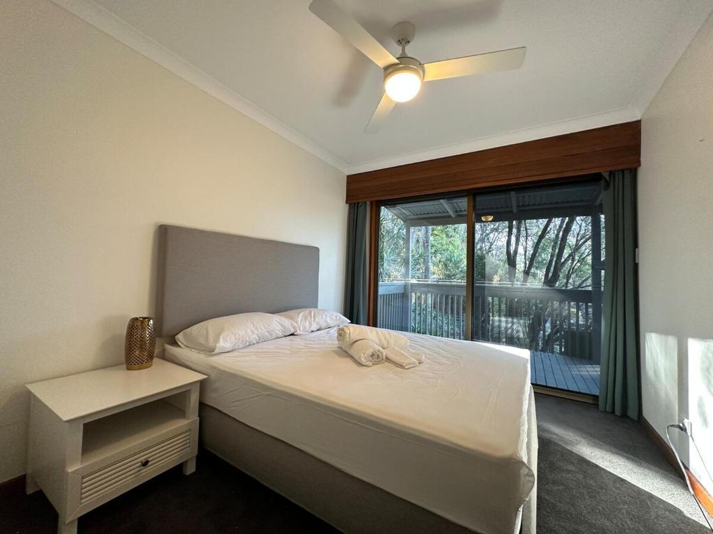ein Schlafzimmer mit einem Bett und einem Fenster in der Unterkunft Luxurious Homely Retreat in Springwood