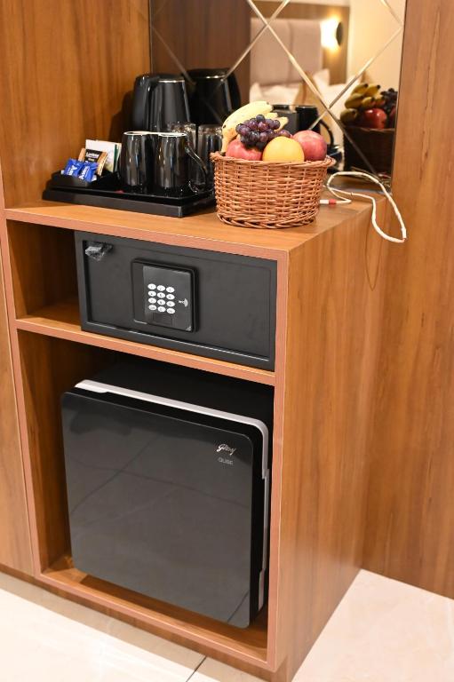 a microwave oven in a cabinet with a basket of fruit at Good One Suites in Bengaluru