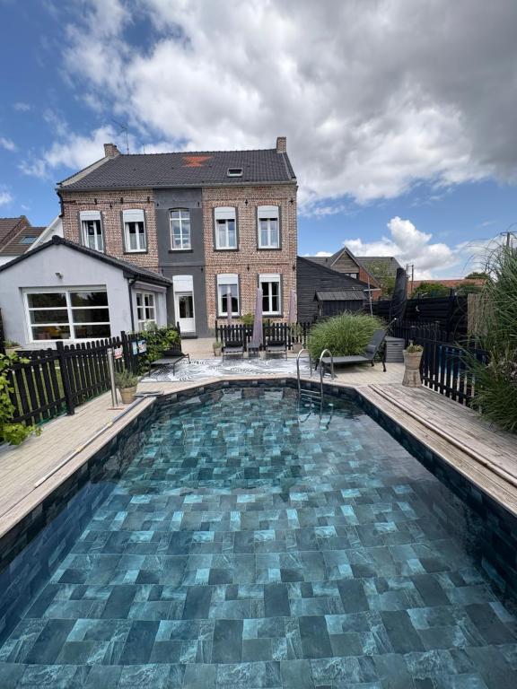 a swimming pool in front of a house at Demeure de caractère du Nord in Ostricourt