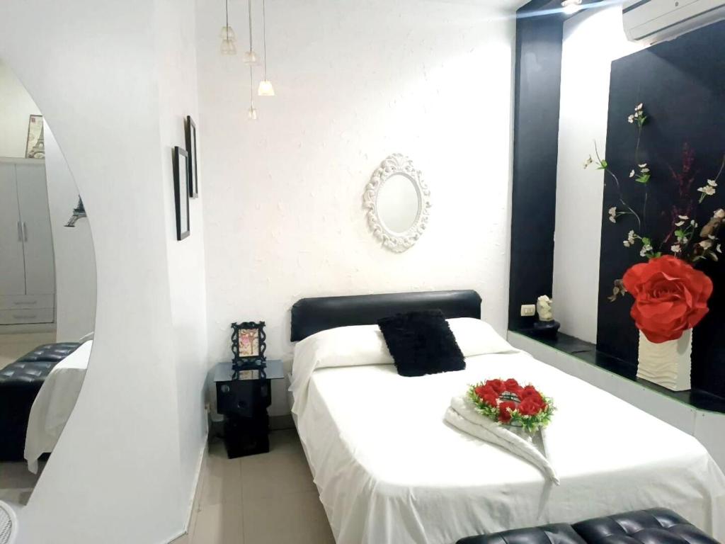 een slaapkamer met een wit bed met bloemen erop bij Stylus Hotel Iquitos in Iquitos