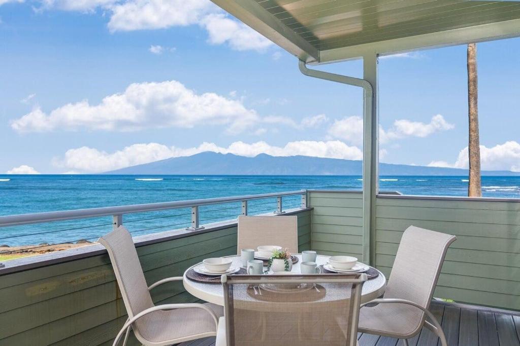a table and chairs on a balcony overlooking the ocean at Kahana Outrigger 3A2 · KHO 3A2 Updated OceanFront 3BD wPool AC O in Kahana