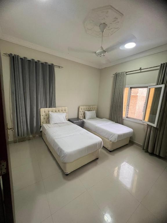 a bedroom with two beds and a window at RED-6 algarbeia in Salalah