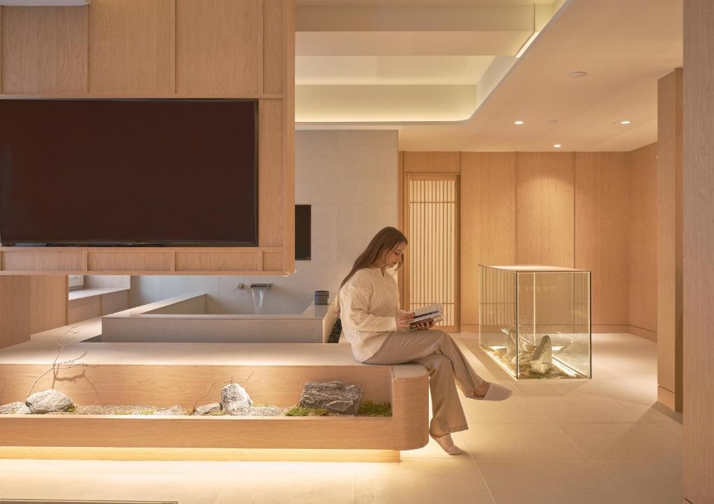 a woman sitting on a bench in a room at UH Continental CenterPoint in Busan