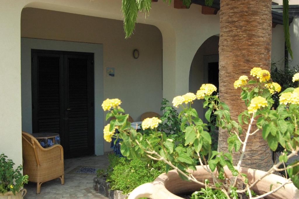 a house with yellow flowers in a yard at Hotel Aura in Vulcano