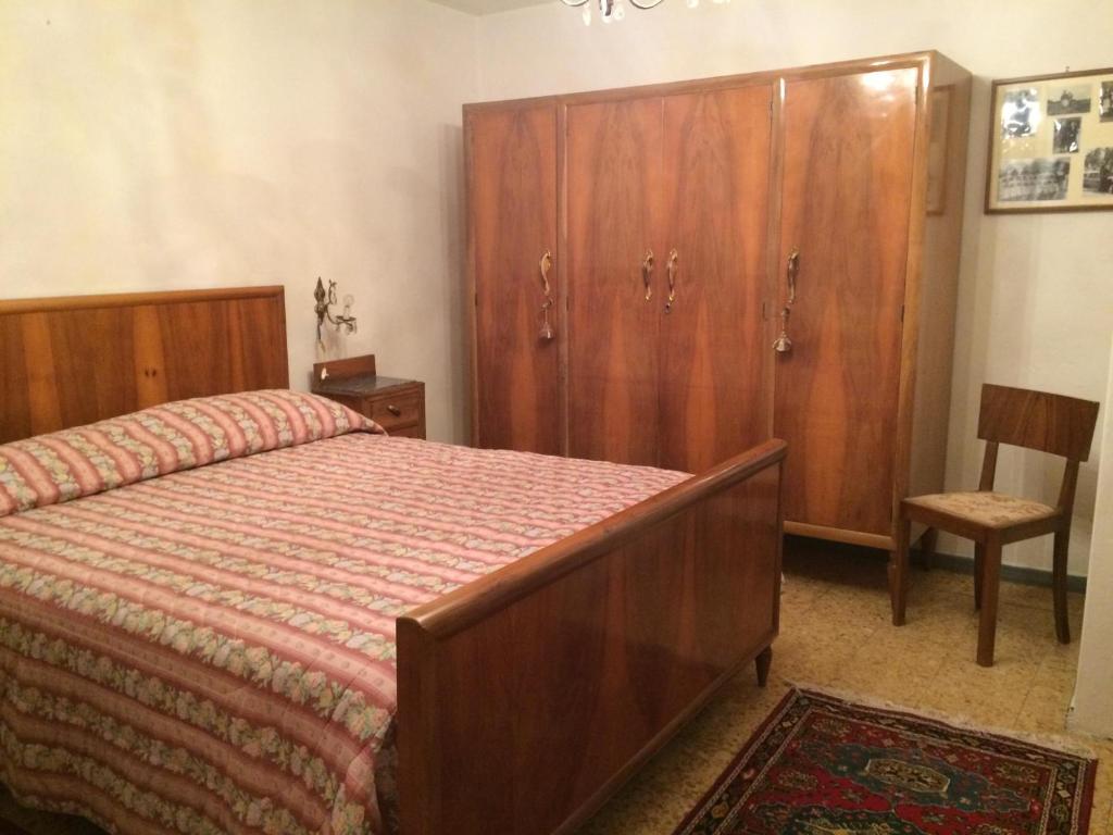 サン・マルチェッロ・ピストイエーゼにあるResidenza Cecchiniのベッドルーム1室(ベッド1台付)、木製キャビネットが備わります。