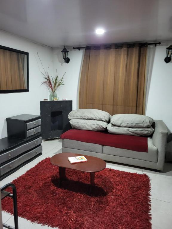 a living room with a bed and a coffee table at Apartastudio con baño privado y chimenea in Chía