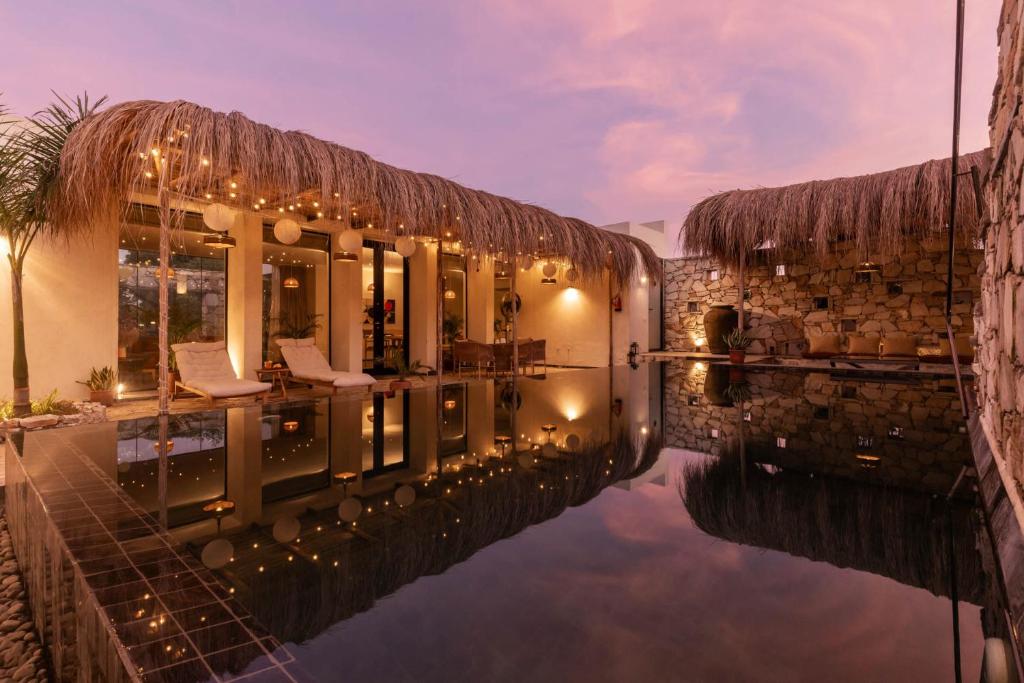 une piscine d'eau en face d'un bâtiment dans l'établissement StayVista at Casa V2 with Pool, WiFi, AC, à Bhāton ki Gali