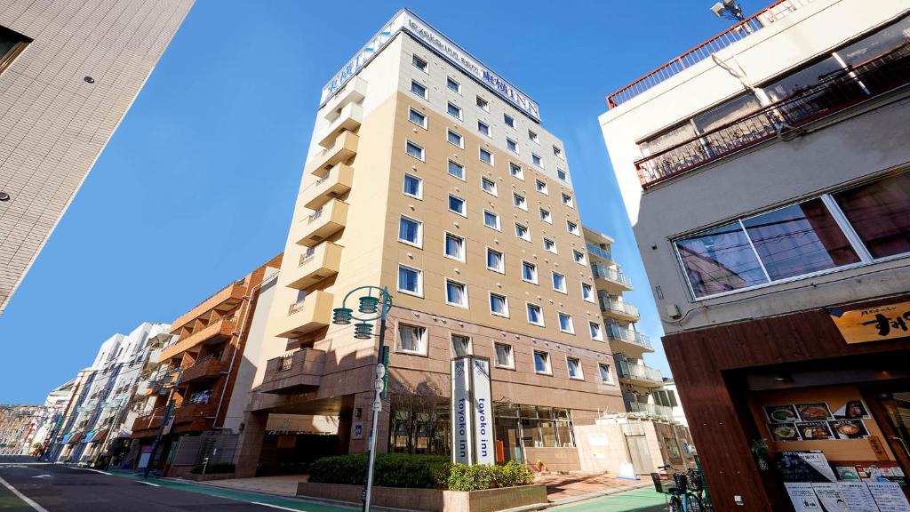 a tall white building on a city street at Toyoko Inn Tokyo Shinagawa Hatanodai eki Minami guchi in Tokyo