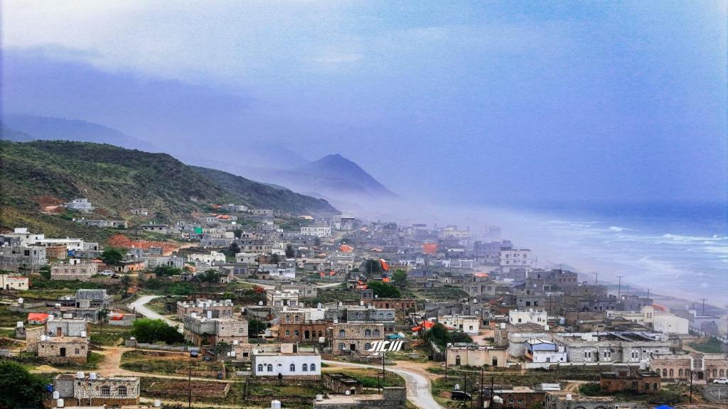 a view of a city with a mountain in the background at محمية حوف 
