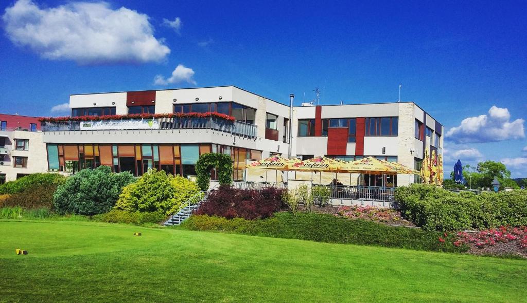 un gran edificio con césped delante en Hotel Beroun Golf Club, en Beroun