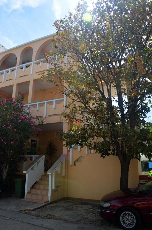 a building with a tree in front of it at Apartments Eufemija in Novalja