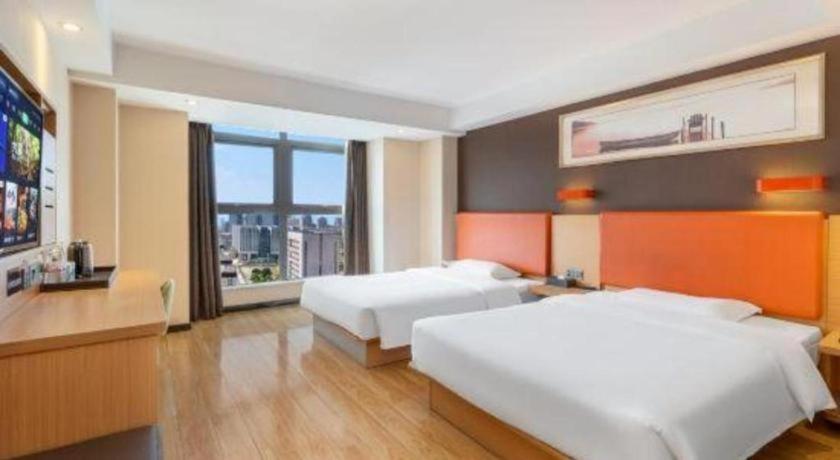 a hotel room with two beds and a flat screen tv at 7Days Premium Chongqing Jiangbei International Airport Rongchuang in Chongqing