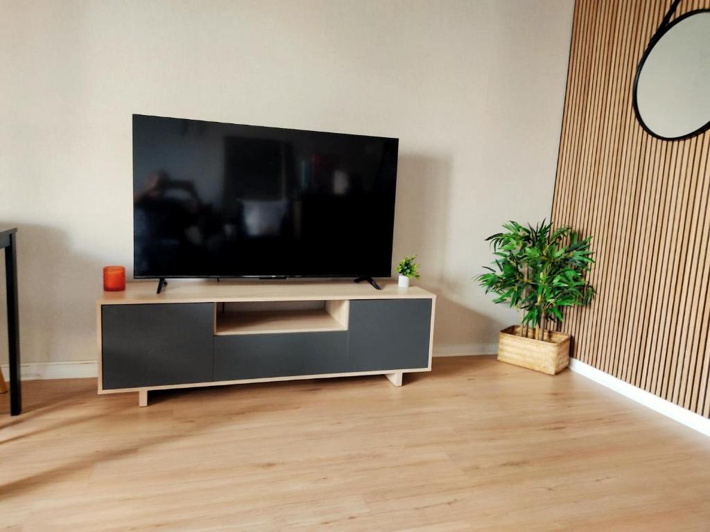 Una sala de estar con un televisor de pantalla plana en un centro de entretenimiento. en Apartamento nuevo con parking y piscina gratis, en Fuengirola