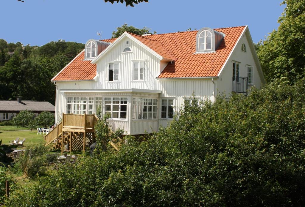 ein weißes Haus mit orangefarbenem Dach in der Unterkunft Villa Akvarellen Bed & Breakfast in Gerlesborg