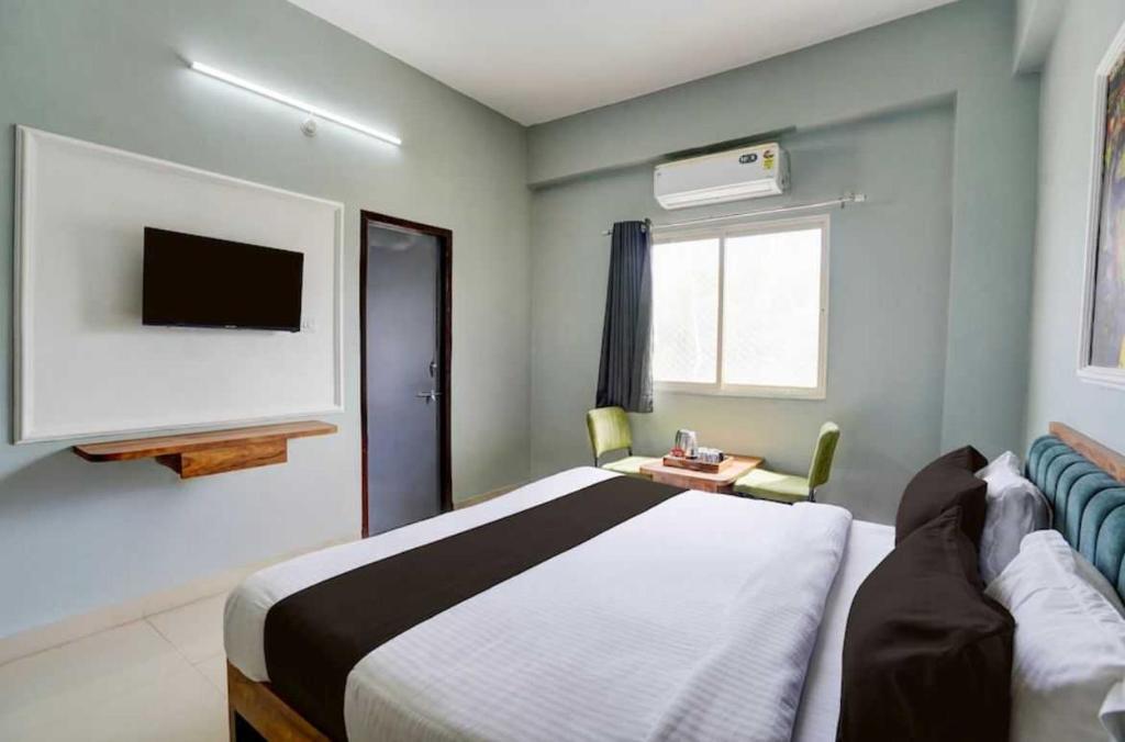 a hotel room with a bed and a tv at Collection O Kesar Crossway Jaipur Formerly Laxmi Palace in Jaipur