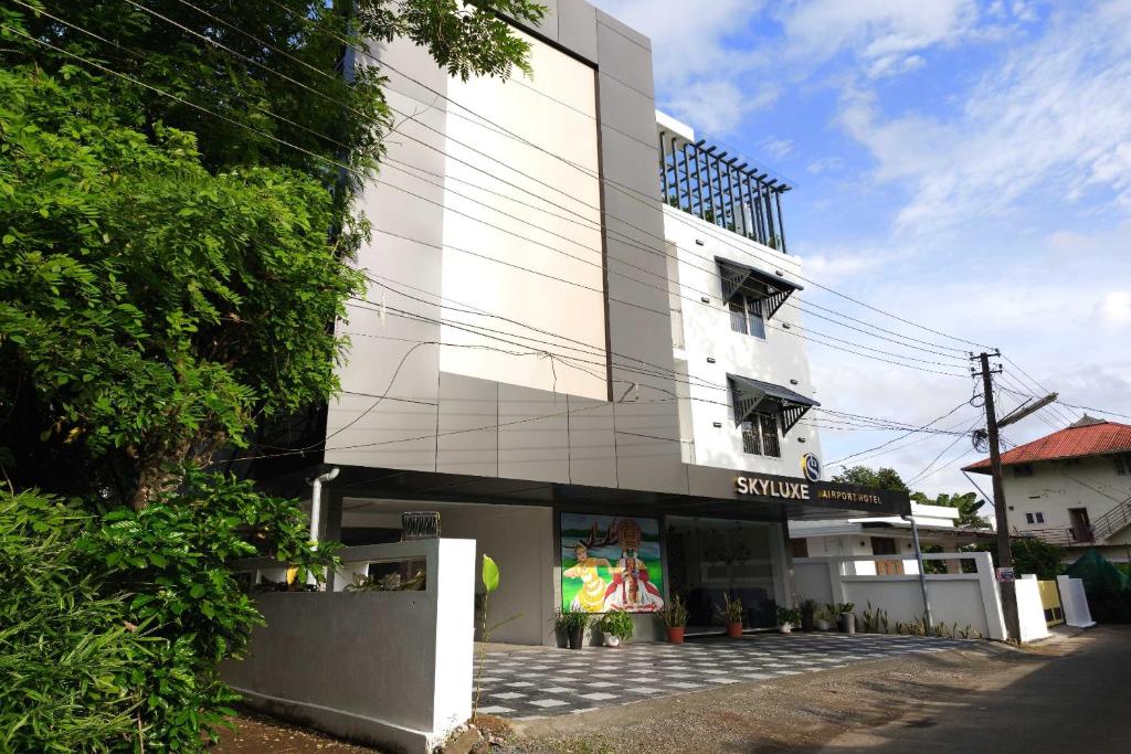 a white building with a sign on the side of it at Townhouse Cochin Airport Formerly Skyluxe in Nedumbassery