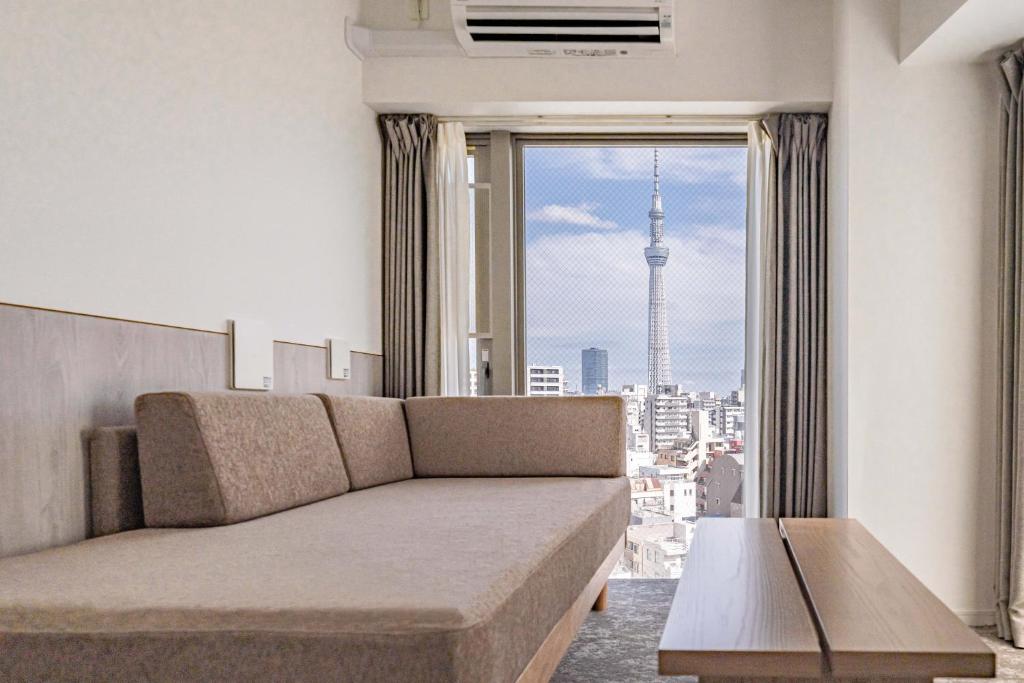 a living room with a couch and a large window at Apartment Hotel 11 Asakusa 1 in Tokyo