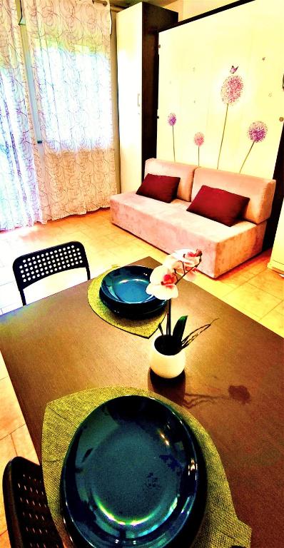 a living room with a table with two plates on it at TT House Rho Fiera Milano Station in Rho