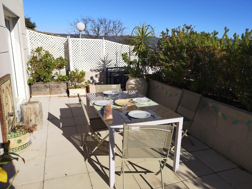 Una mesa y sillas en un patio. en Superbe Appartement 2 Chambres, en La Ciotat