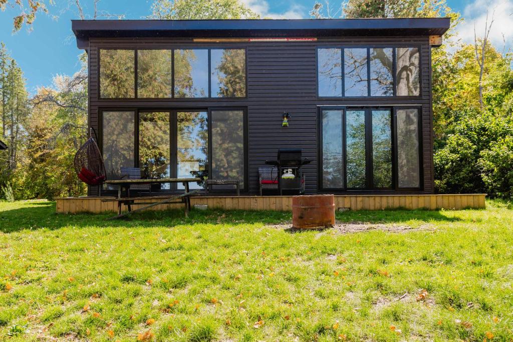 a black tiny house with a large window at 3-bedroom Lakefront Villa #10 in Lakefield