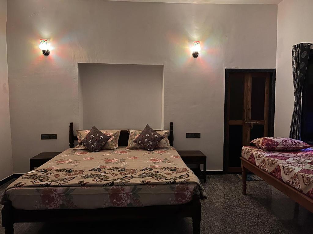 a bedroom with a bed and two lamps on the wall at Chitrak stays Jawai in Bijāpur