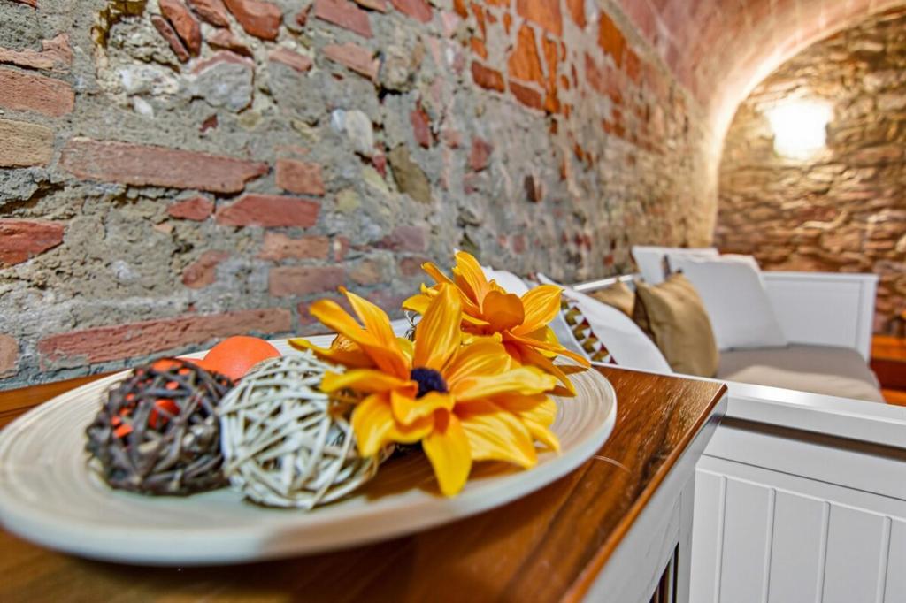 a plate with a yellow flower on a table at Casa Chopin - ToscanaOneHH in Laiatico