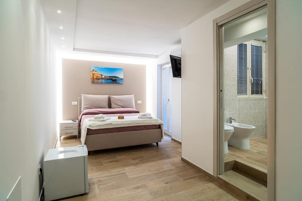 a small bedroom with a bed and a mirror at Brezza marina in Santa Maria di Castellabate