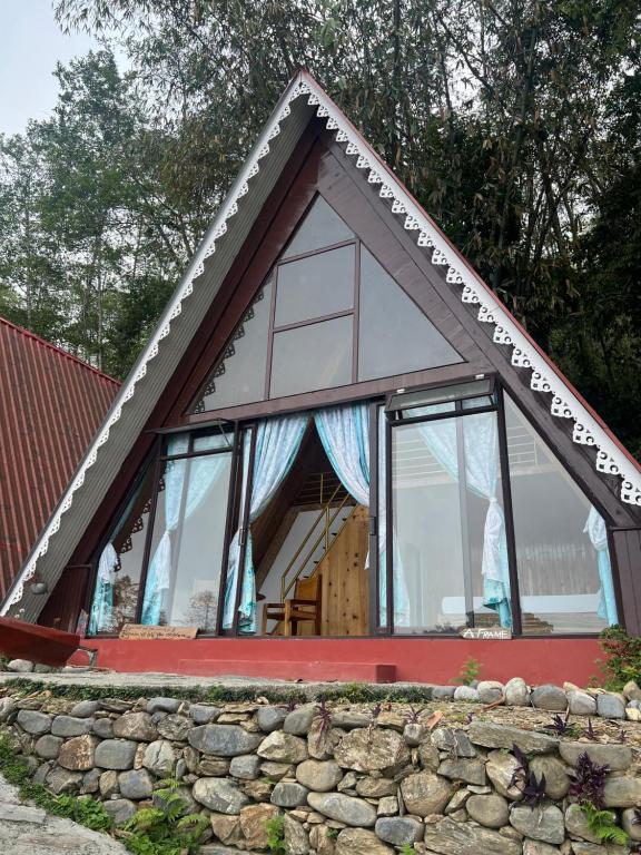 a small house with a window on top of a stone wall at Annapurna Nature Retreat, Namchi South Sikkim in Singtām