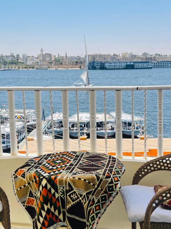 a table and chairs on a balcony overlooking the water at Toutankhamon in Luxor