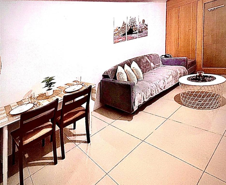 a living room with a couch and a table at Staycation Near Mall of Asia in Manila