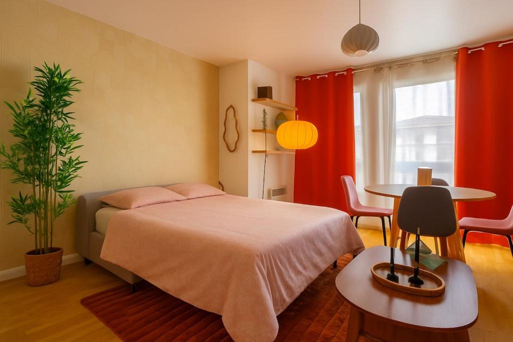 a bedroom with a bed and a table and chairs at Heaven Loft - proche RER A - DISNEY LAND in Bussy-Saint-Georges