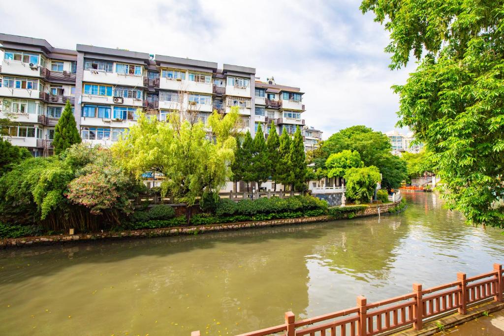 a river with a fence next to a building at Confucius Temple Yisu Hotel in Gaoqiao