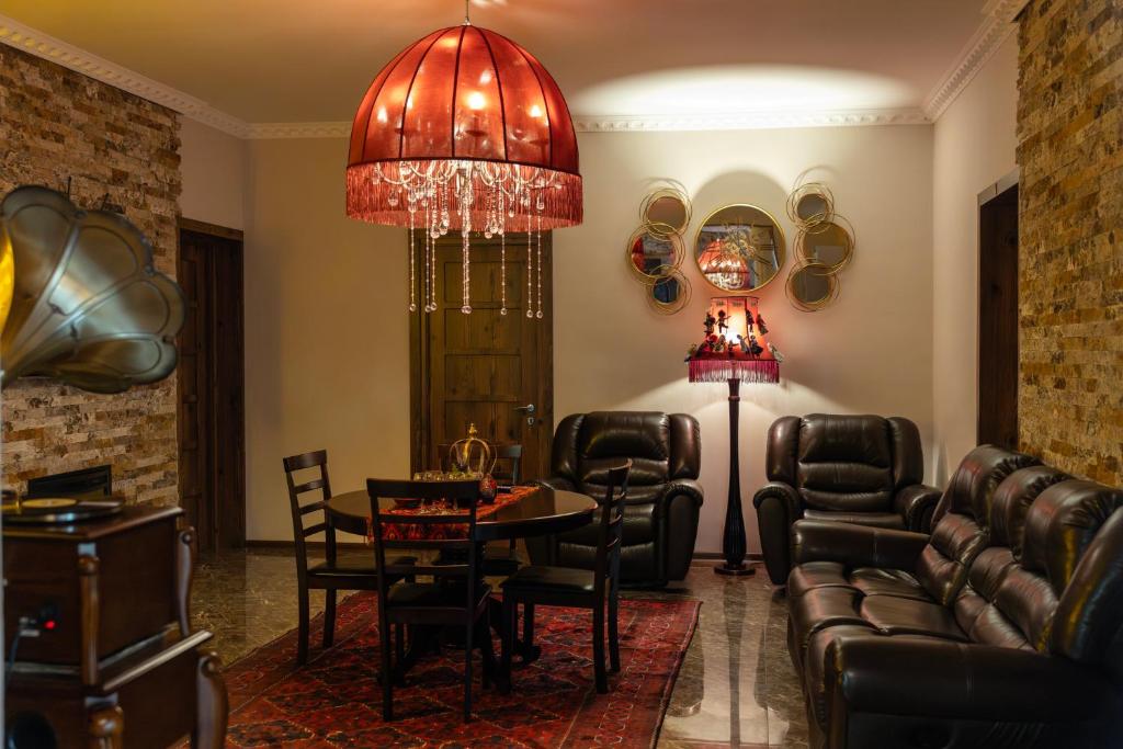 a living room with leather furniture and a chandelier at Hestia Boutique Hotel in Gori