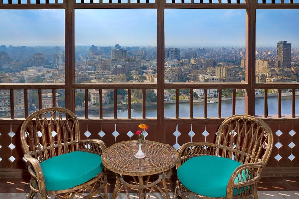 a balcony with a table and chairs and a view of the city at Cairo World Trade Center Hotel & Residences in Cairo