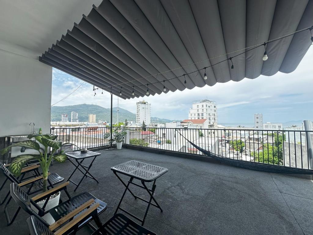 a balcony with chairs and tables and a view of a city at Rami Xanh Stay in Danang