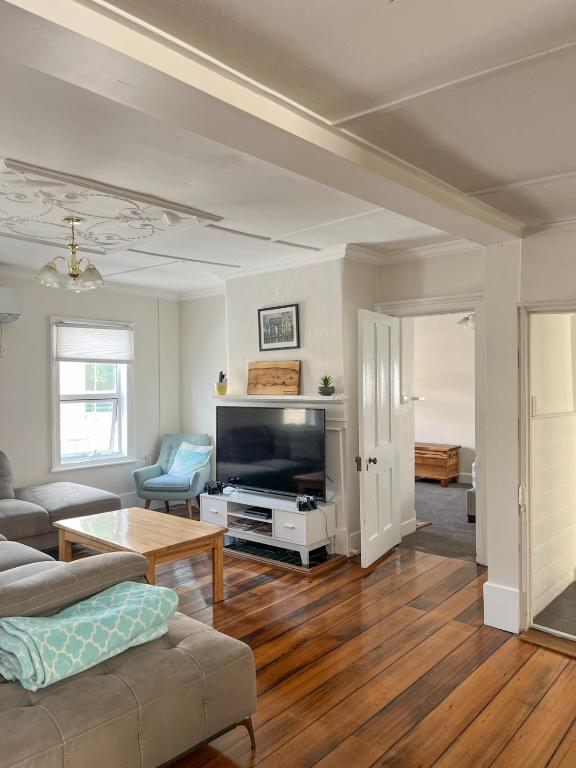 a living room with a couch and a tv at 128 Murray - Sassafras in Hobart