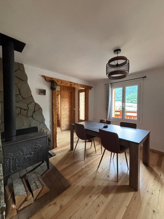 a dining room with a table and a fireplace at Le montagnard in Le Monêtier-les-Bains