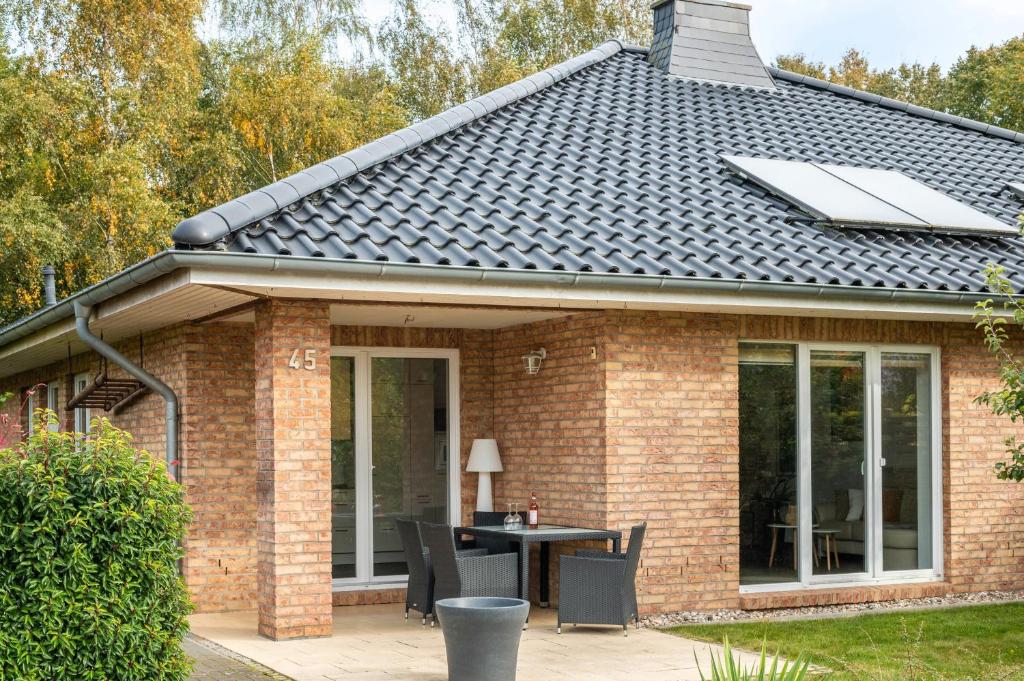 a house with a roof with a table on a patio at Großes Ferienhaus Im Grünen - in Beselin