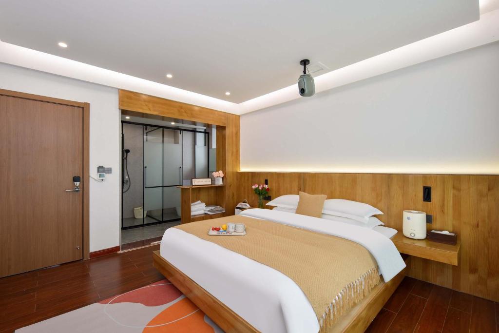 a bedroom with a large bed and a shower at Da Le Zhi Ye Homestay in Shangri-La