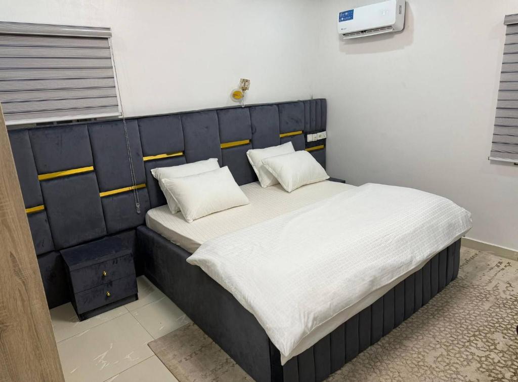 a bedroom with a bed with a blue headboard at Luxurious 3BR Apartment 247 Power City views in Kadobunkuro