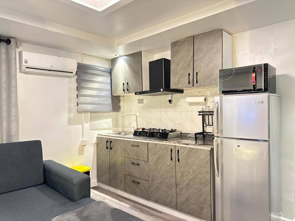 a kitchen with a stainless steel refrigerator and a couch at Luxurious Abuja Apartment with Private Entrance Central AC in Garki
