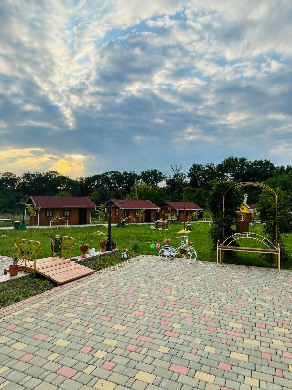 a park with a bike parked on a brick patio at La Nea Ion in Ţaul