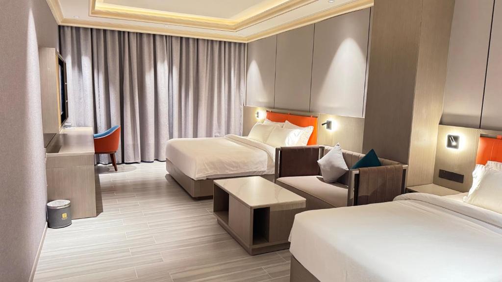 een hotelkamer met twee bedden en een bank bij Amaris Hotel in Barka