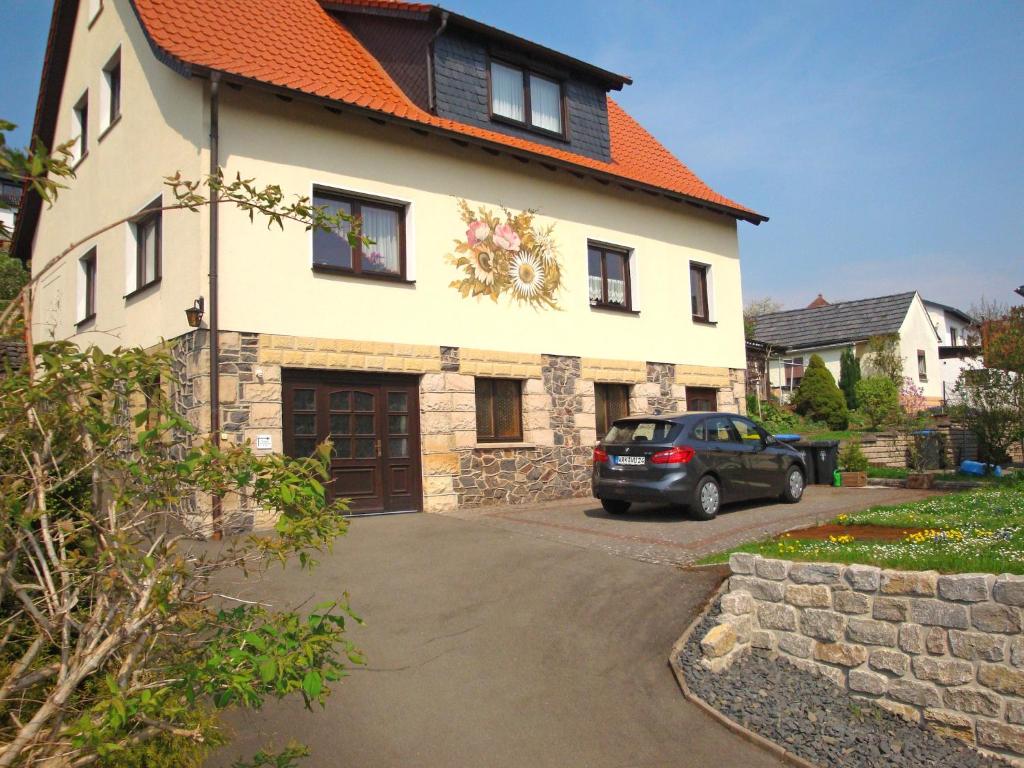 a car parked in front of a house with an orange roof at holiday home in the Thuringian Forest with roof in Bad Liebenstein