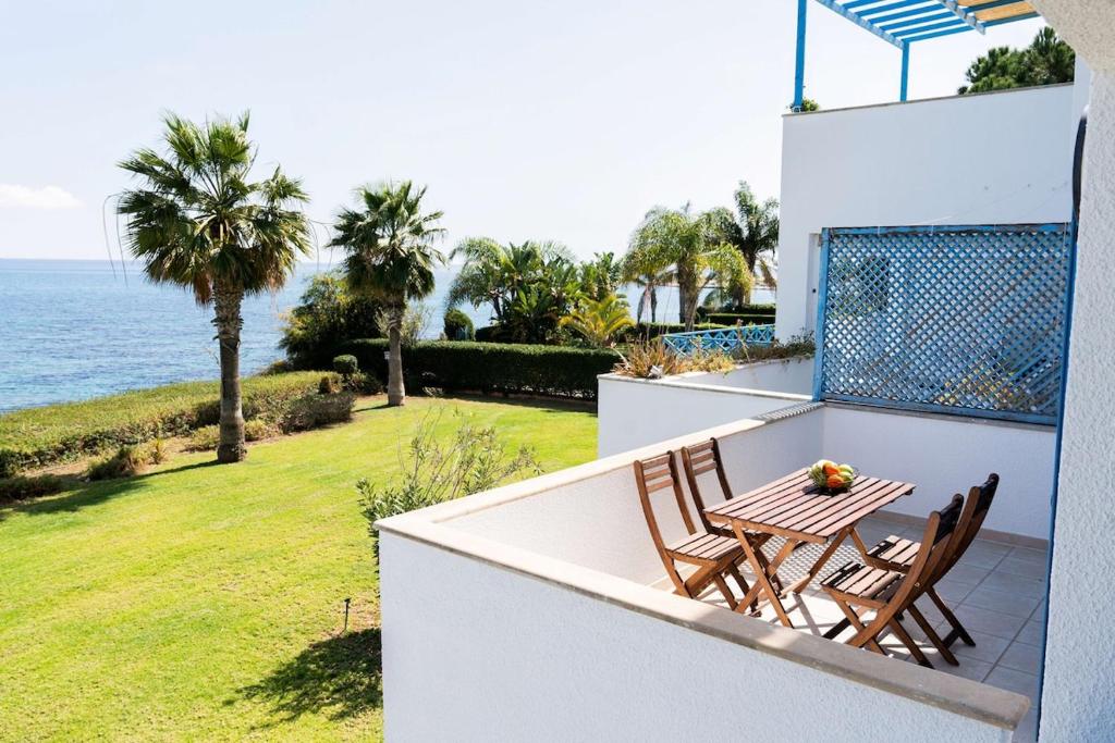 a table and chairs on the balcony of a house at Beachfront Mediterranean Escape 3bd Sea View Apartment in Pendakomo