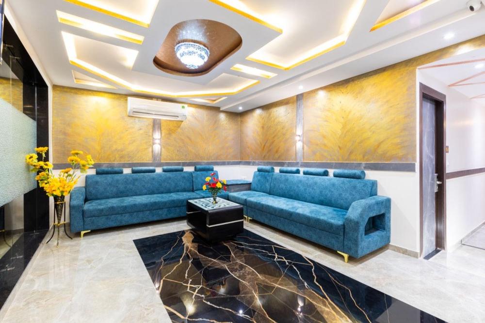 a living room with blue couches and a ceiling at Anex Hotel Near BKC in Mumbai