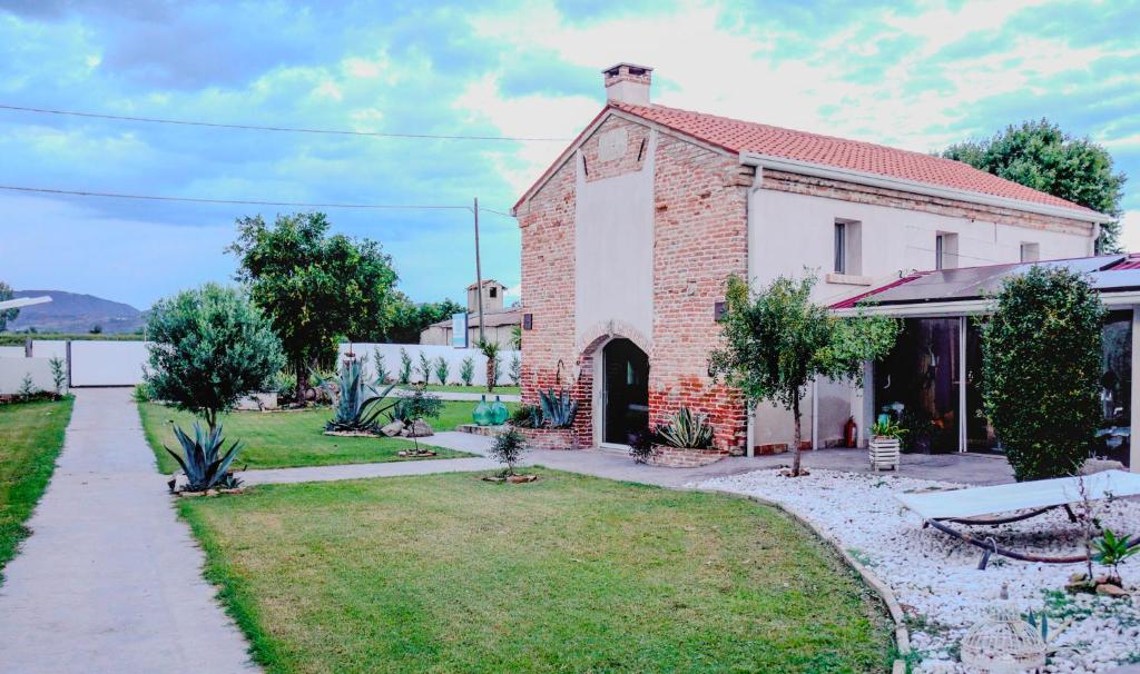 ein altes Backsteinhaus mit einem Garten davor in der Unterkunft Villa Nides in Monselice