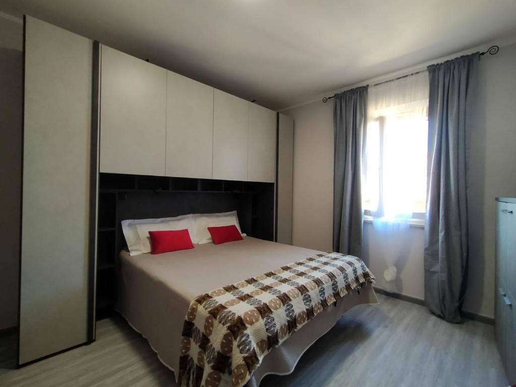 a bedroom with a bed with red pillows and a window at WoW San Miniato in San Miniato