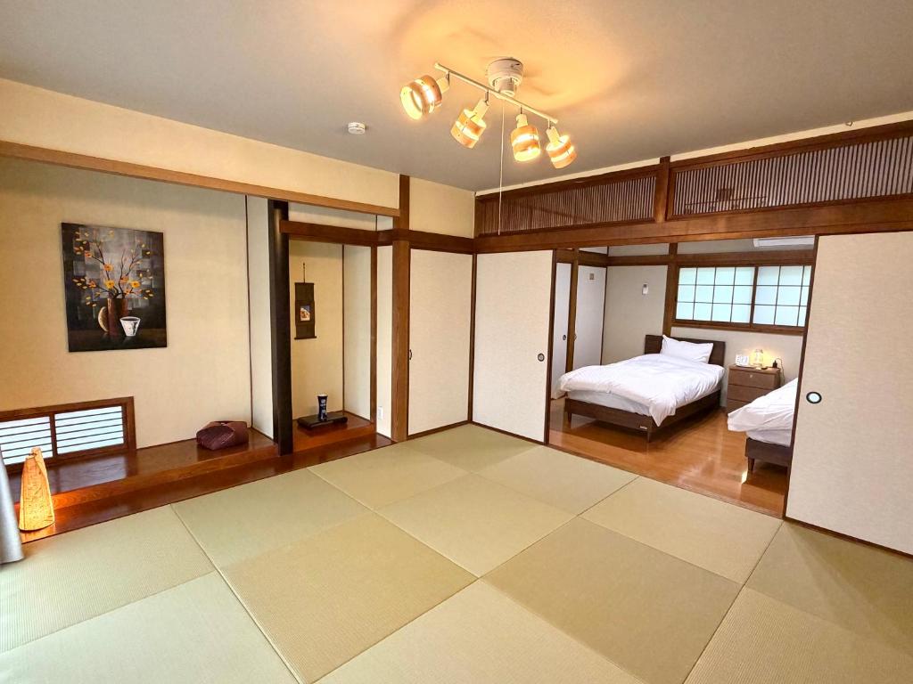 a large room with a bed and a bedroom with a ceiling at かみくまハウス in Kumamoto