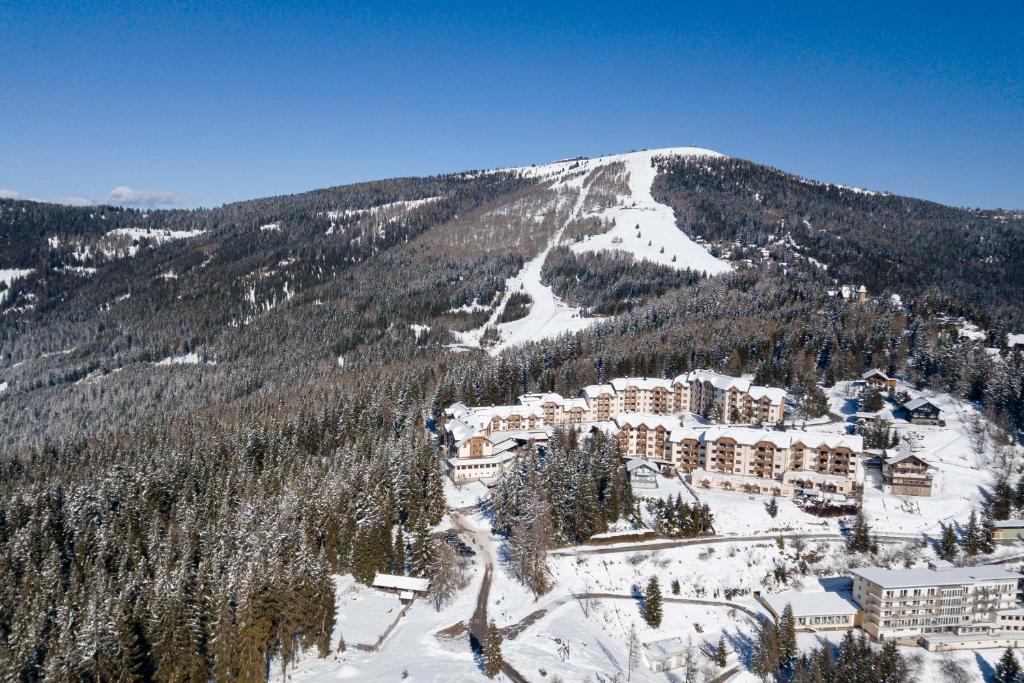 a view of a resort in the snow with a mountain at Bergresort Gerlitzen by ALPS RESORTS in Treffen